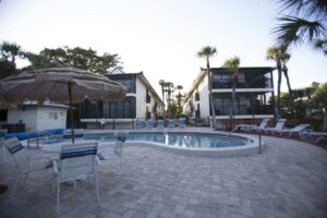 pool with umbrellas and chairs, Sunburst Condo buildings in background