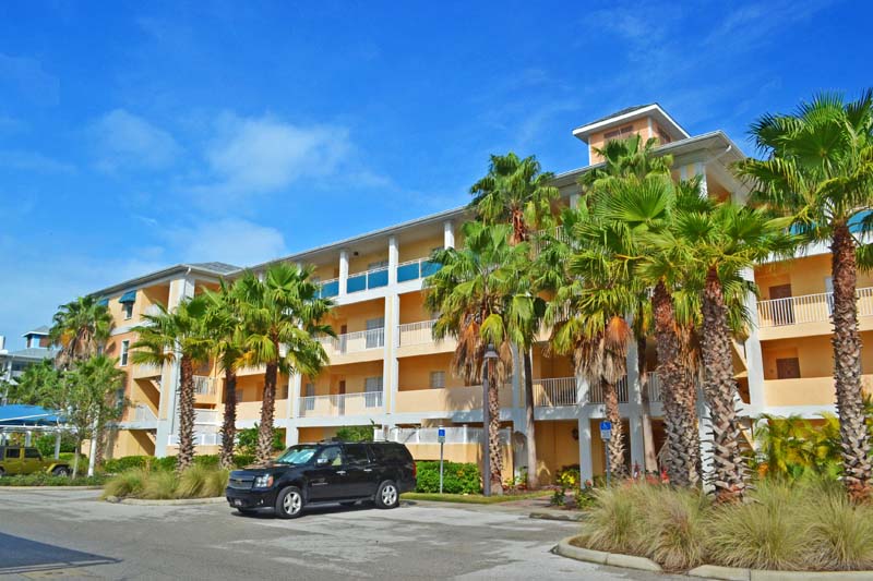 four story Cape Haze Resort condominium building with palm trees and parking in front of it