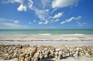 sand beach with rocks in foreground