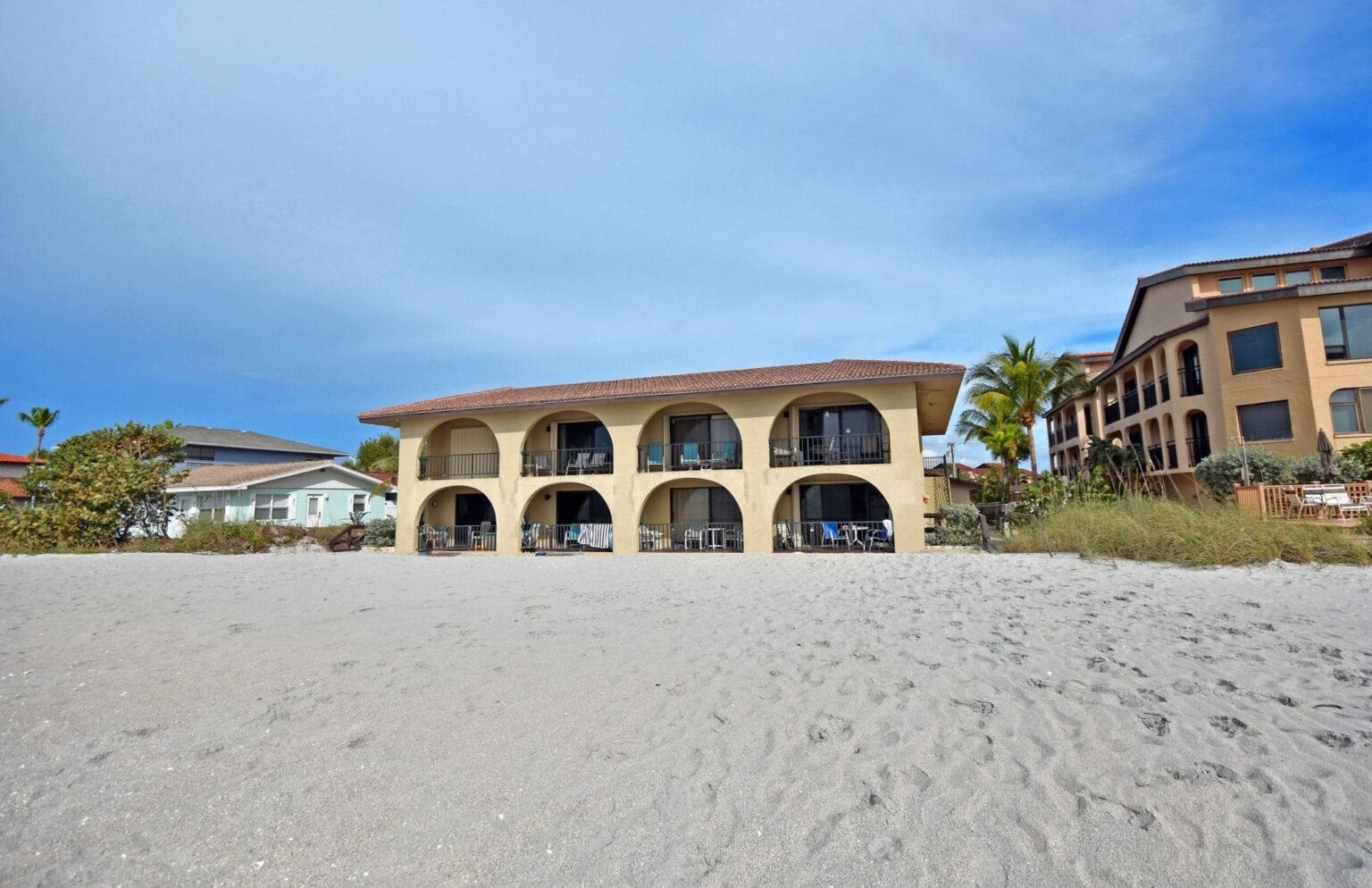 two story El Galeon Gulf Condos building with beach in foreground