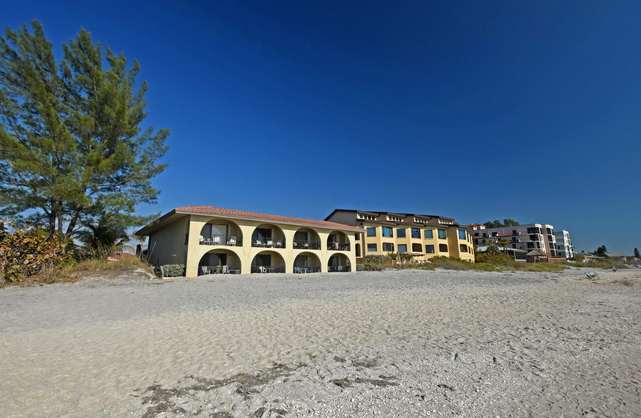 two story El Galeon Gulf Condos building with beach in foreground