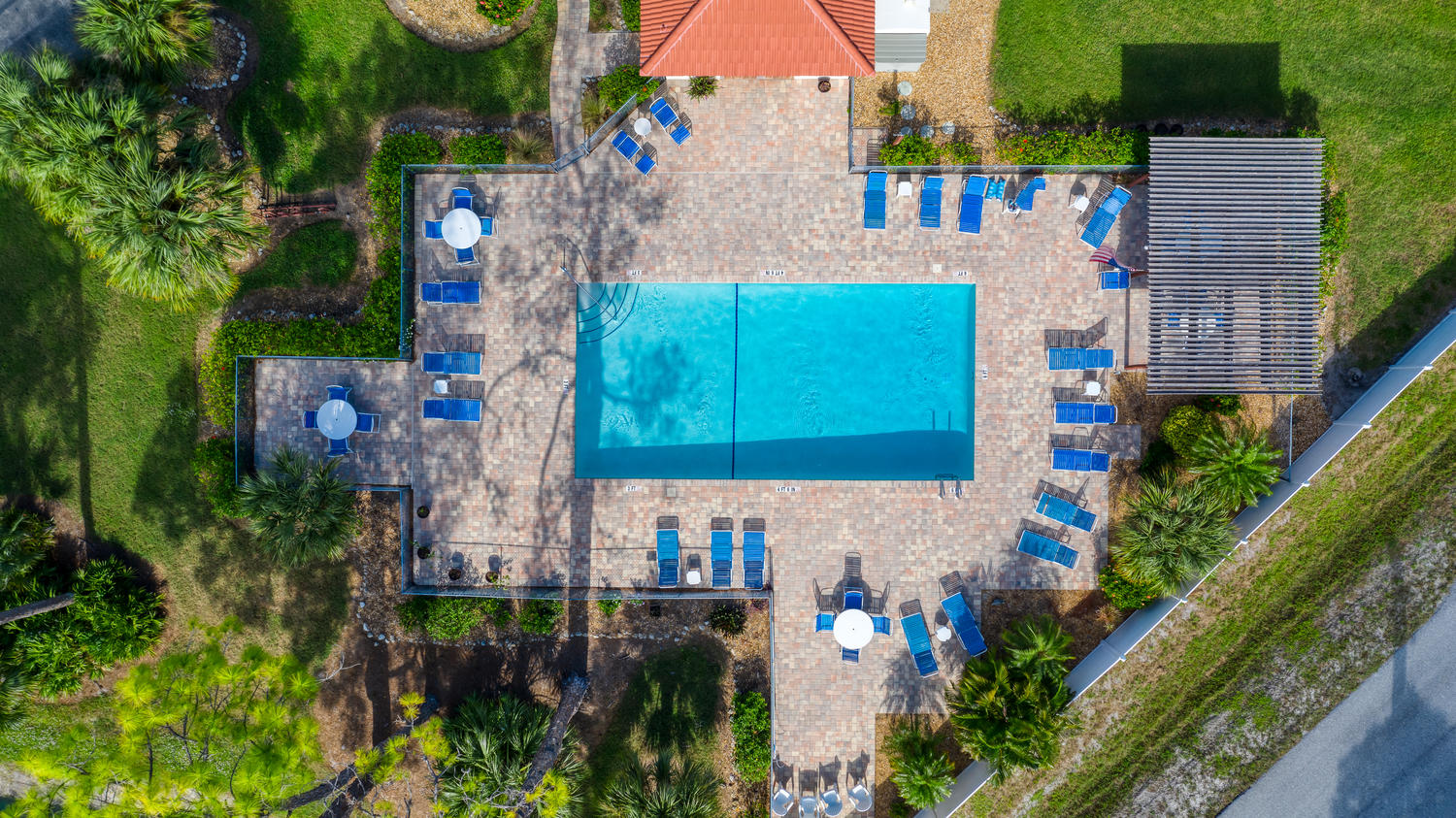 aerial view of pool with recliners around it