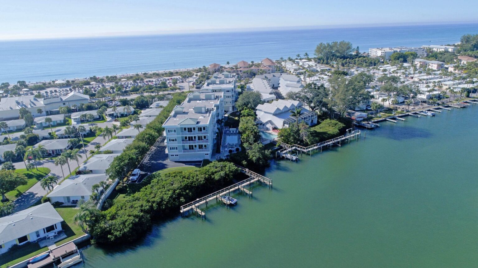 aerial of Sunrise Pointe condominium buildings with Intracoastal in foreground and beach in background