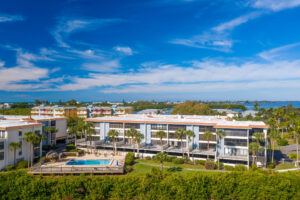 aerial view of multi story condo building with pool in foreground