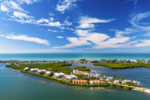 aerial looking at Sandpiper Key Condominiums buildings with intracoastal in front and ocean in the background