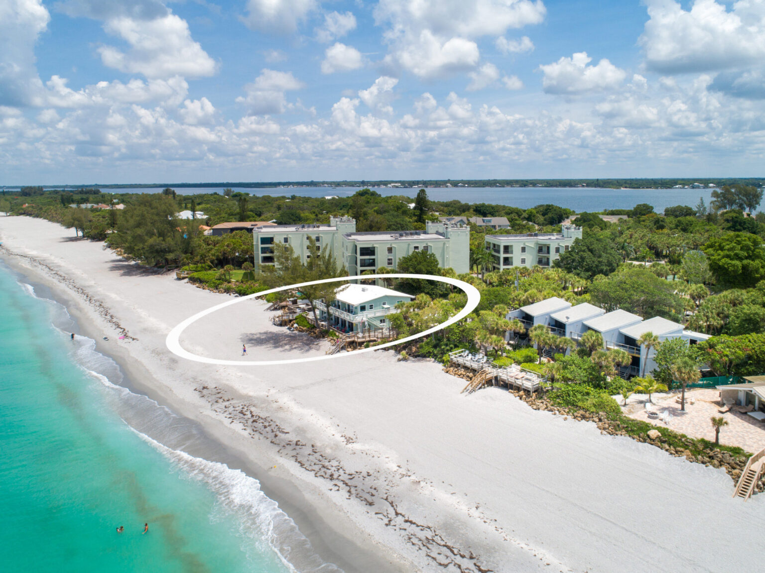 aerial of two story seabreeze condo building right next to beach
