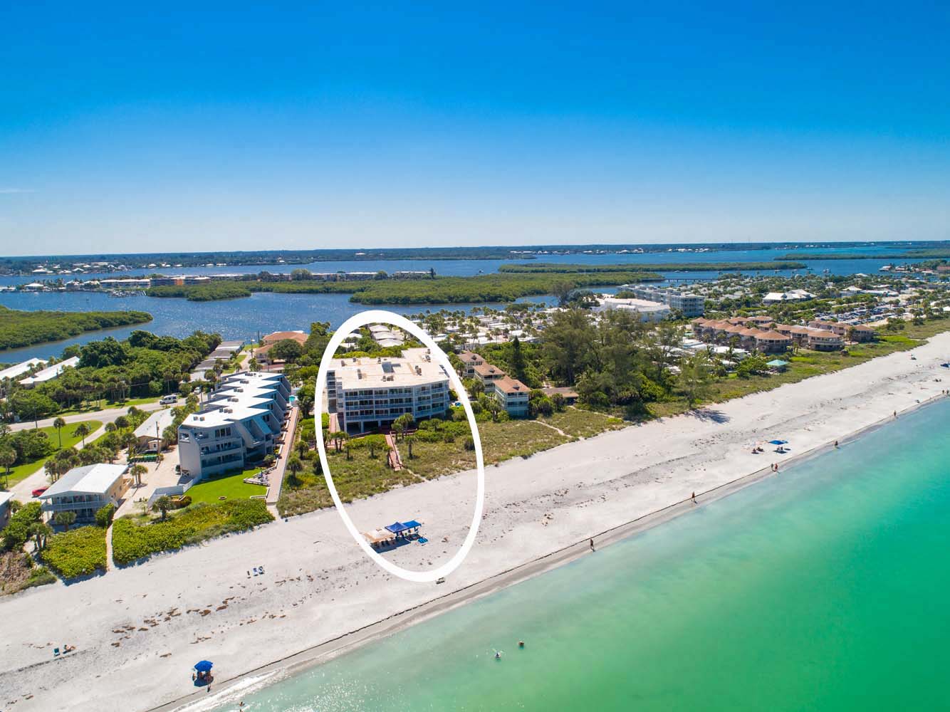aerial of Surf Club building looking at it from the ocean showing beach in the foreground and the intracoastal in the background