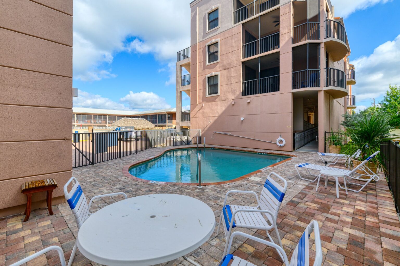 small pool with a couple recliners and a few chairs visible