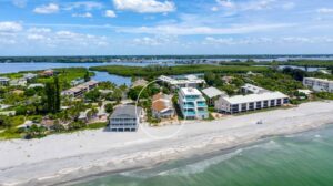 aerial view from water looking at condominium building right next to the beach